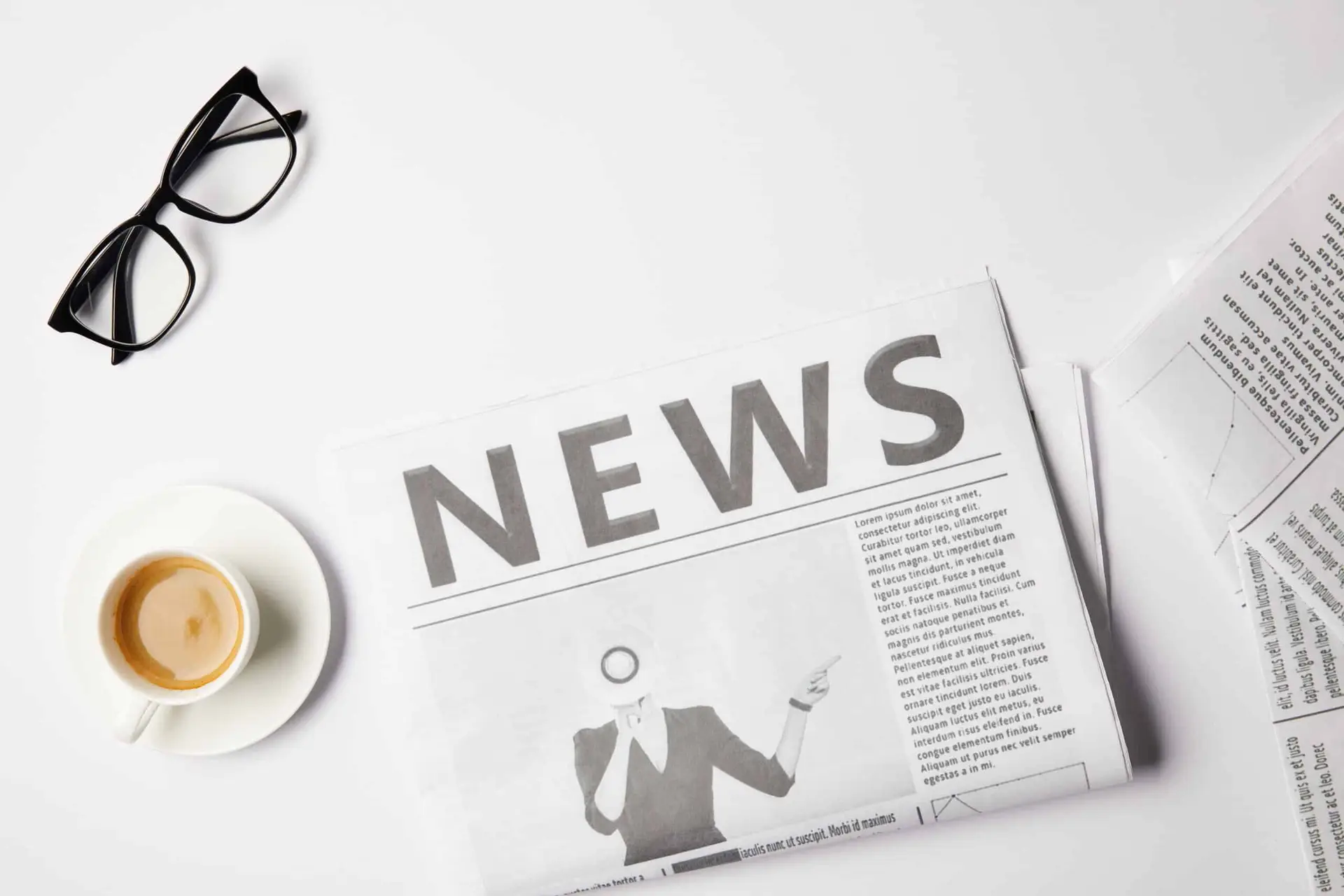 top view of eyeglasses, coffee cup and newspapers, on white