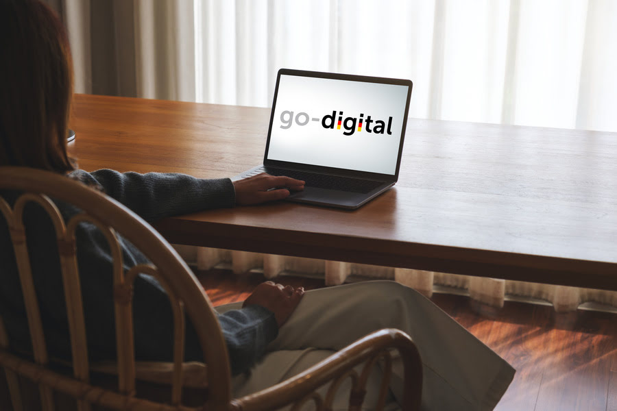 ein laptop steht auf dem tisch mit go-digital logo drauf